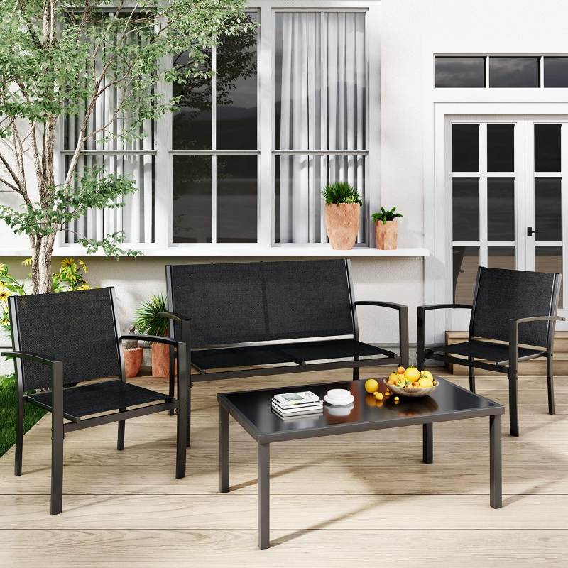 Outdoor patio set with black chairs and table on a wooden deck.