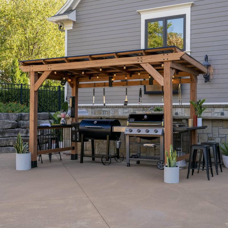 Outdoor patio with wooden pergola, barbecues, and potted plants.