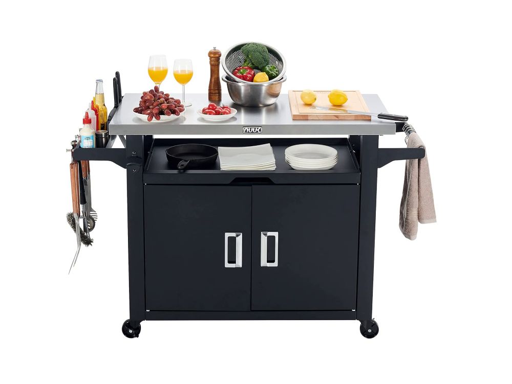 Black kitchen island with a stainless steel countertop, various kitchen items, and cabinets.